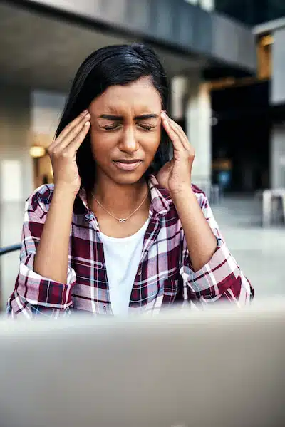 woman holding her head due to experienced tension headaches